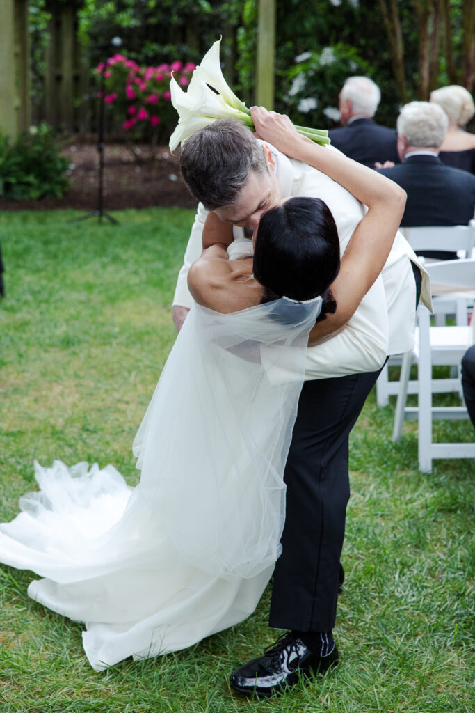 Bride is dipped and kissed by groom as they walk down the aisle after being wed