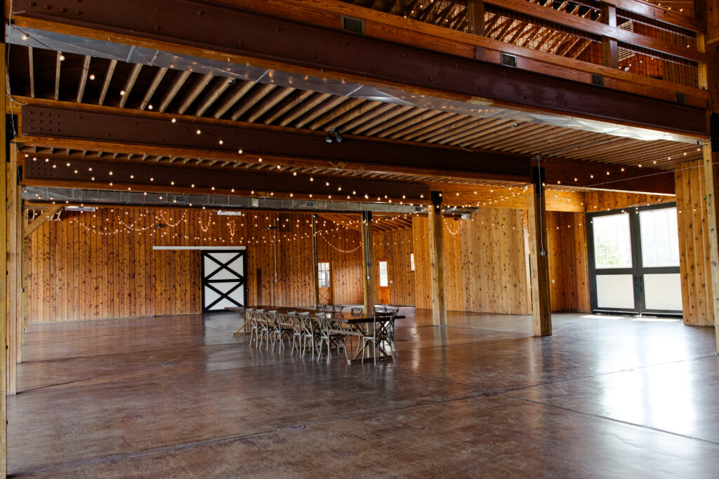 Luxurious barn, empty room with lights and large space for creating a wedding reception.